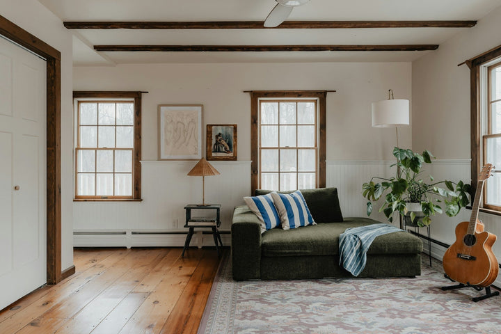 An 8x12 vintage rug in neutral and vibrant colors is central to the living room, enhancing its cozy and welcoming atmosphere. The room also features plush couch