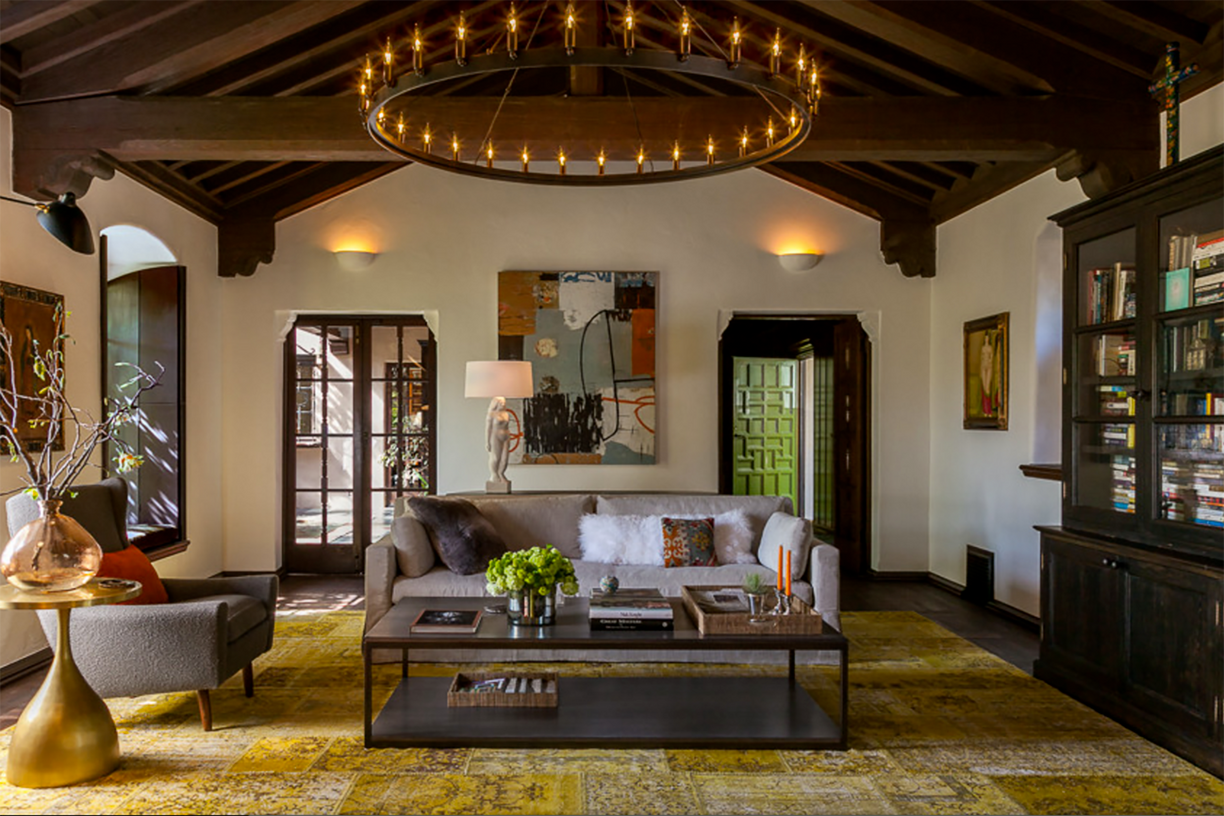 Stylish and cozy living room with a rustic yet modern aesthetic. The layout features a central seating area with a light gray sofa adorned with patterned cushio