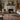 The living room is illuminated by a warm glow, with a large 10x12 hand-woven Turkish rug in soothing neutral tones at its centre. The room is enhanced by soft d