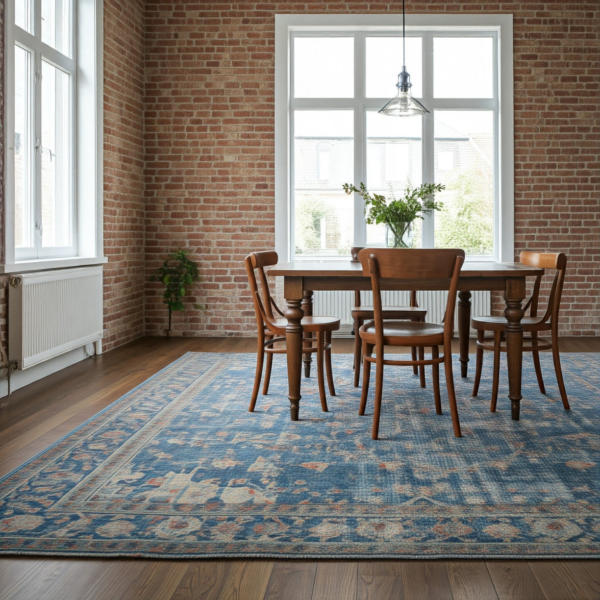 A modern, minimalist dining room with a rustic touch. The rectangular wooden dining table is surrounded by four matching wooden chairs, all set on a large, intr