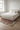 Beige vintage Turkish area rug 6x10 feet under bed in minimalist Scandinavian bedroom